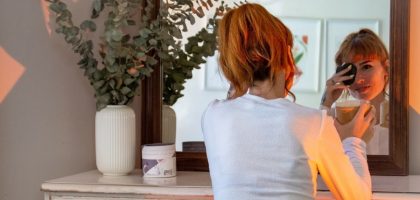 Woman enjoys a cozy morning routine with makeup and coffee in a stylish Montréal apartment.