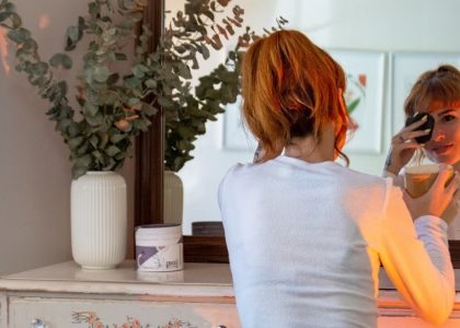 Woman enjoys a cozy morning routine with makeup and coffee in a stylish Montréal apartment.